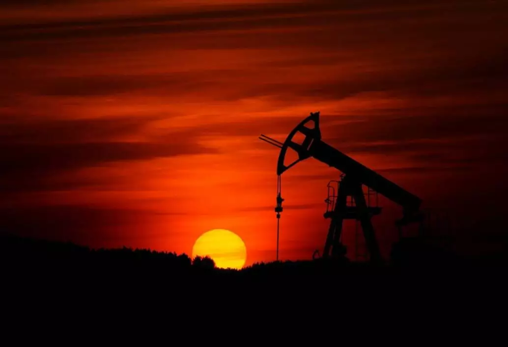 oil rig silhouetted by sunset