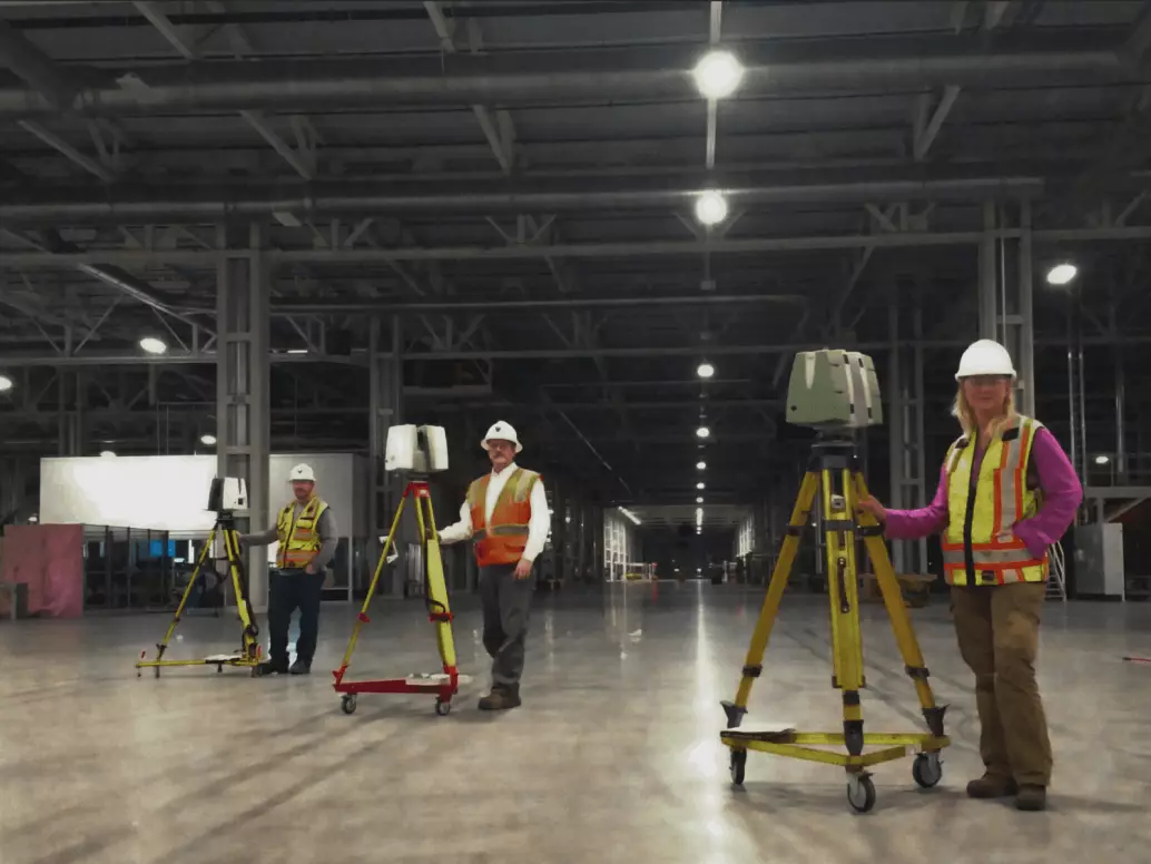 three technicians posed with their 3d scanning equipment in the Mercedes Benz factory